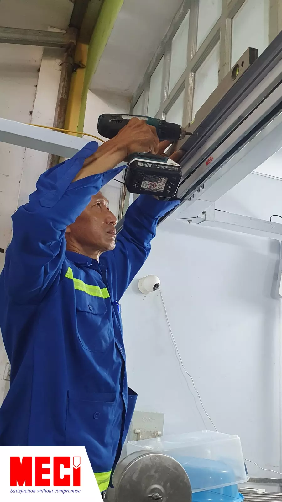 Anh kỹ thuật MECI đang khoan thanh ray vào tường