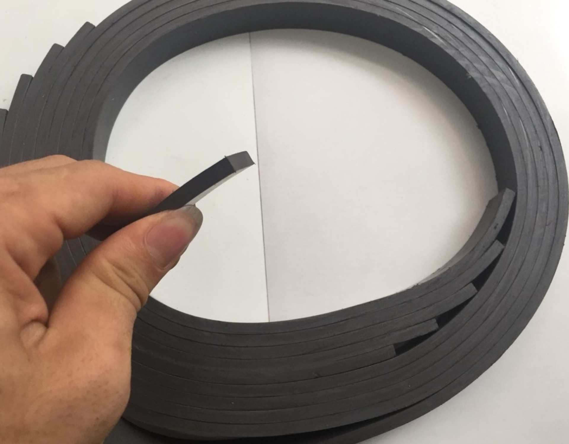 cuộn nam châm sợi được cuộn tròn có 1 bàn tay cần 1 đầu sợi nam châm đưa lên