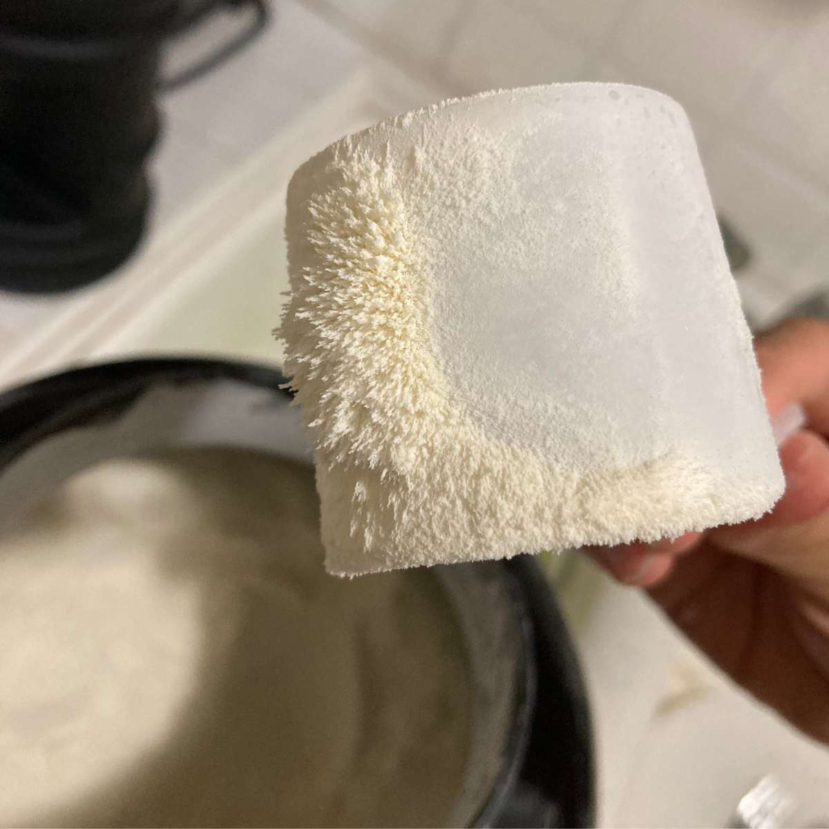 Chiếc muỗng nhựa trắng bám đầy bột trắng xung quanh