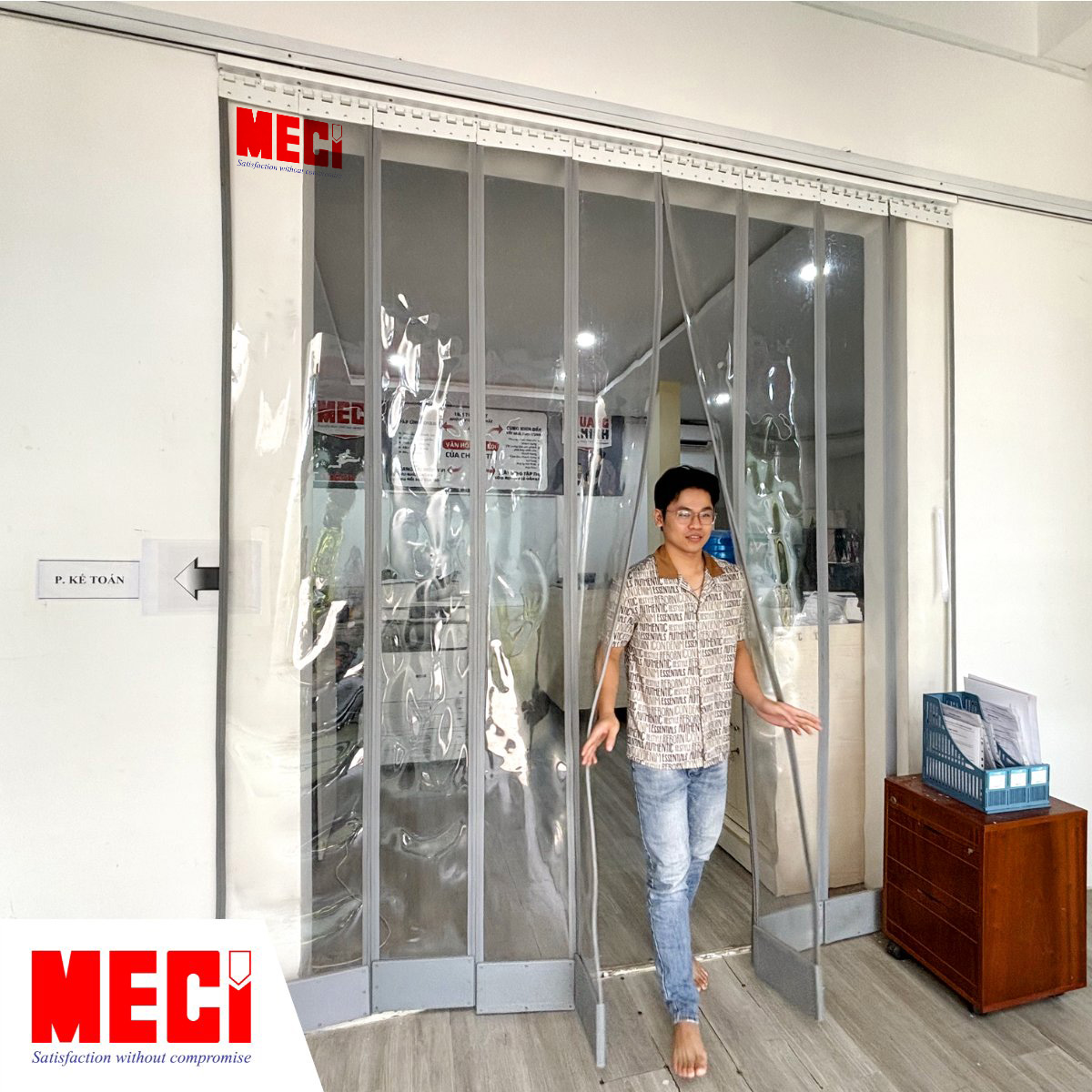 một người nam vén rèm nam châm và đi ra, rèm được lắp ở lối ra vào văn phòng