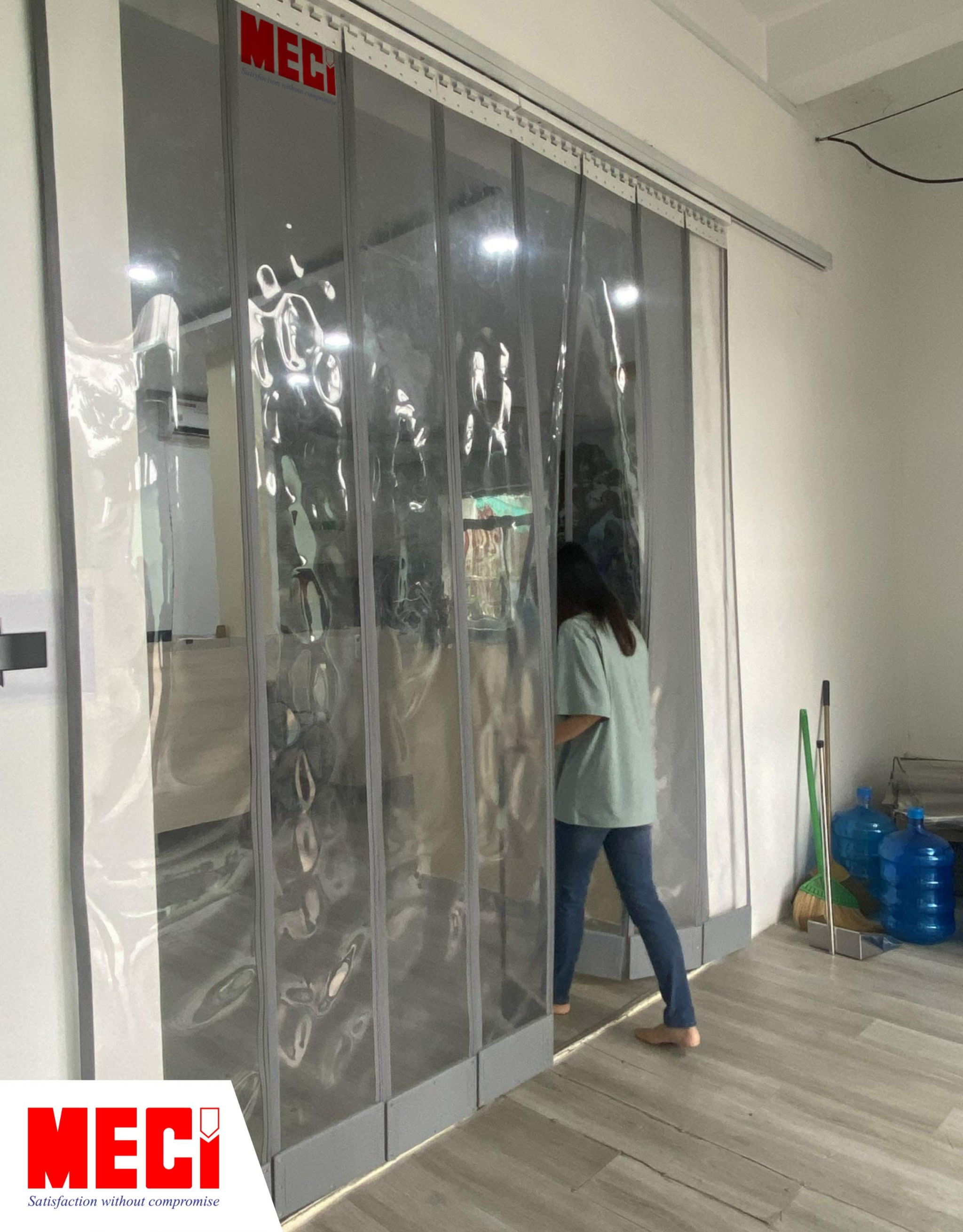 một người đi qua cái rèm nam châm trắng trong được lắp ở văn phòng