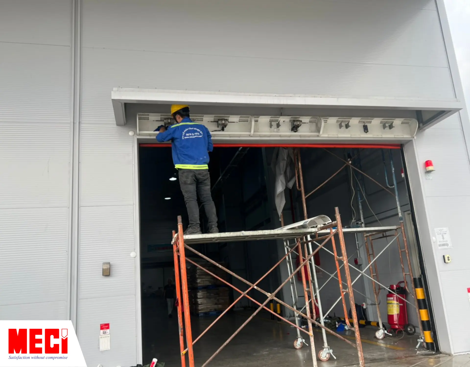 Kỹ thuật MECI đang vệ sinh vỏ sau của quạt bằng khăn khô