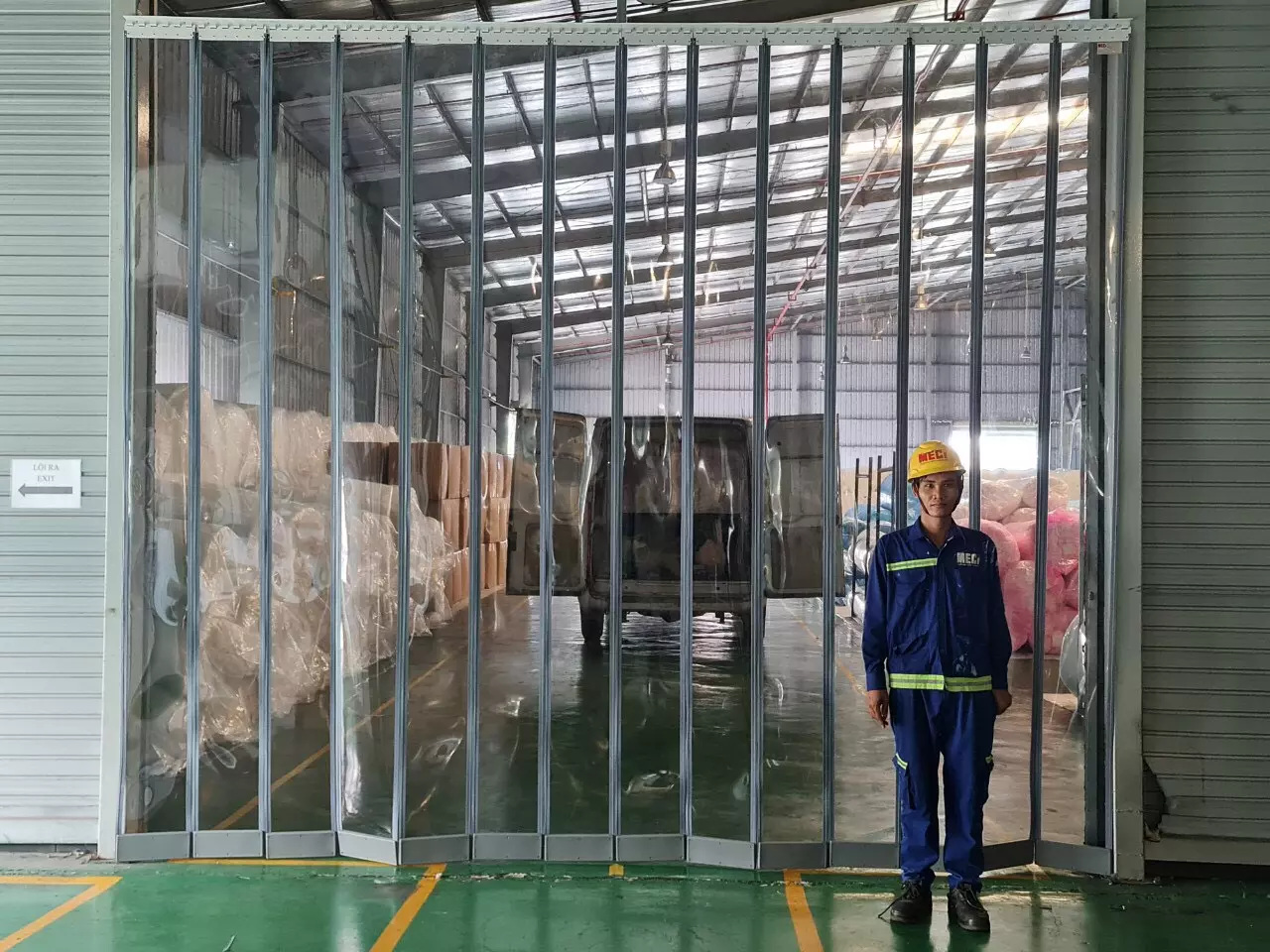 Anh lỹ thuật MECI đang đứng trước rèm nhựa nam châm 