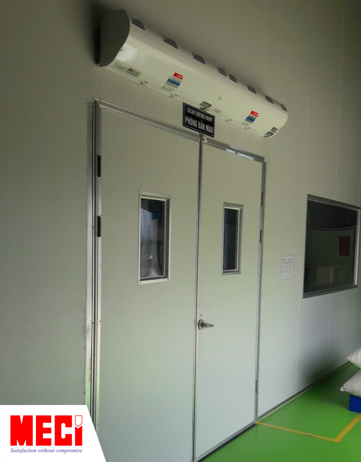 quạt cắt gió công nghiệp lắp phía ngoài lối ra vào phóng sạch bên dưới có cửa đang đóng kín