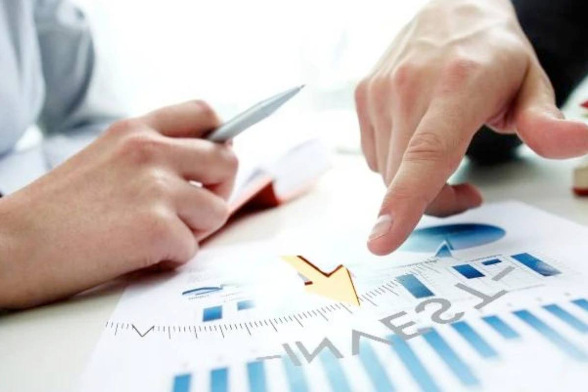 Hai bàn tay đang chỉ lên tập tin để trên bàn.