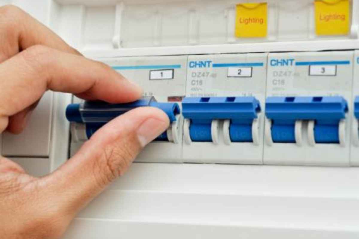 Bàn tay đang tắt công tắc điện