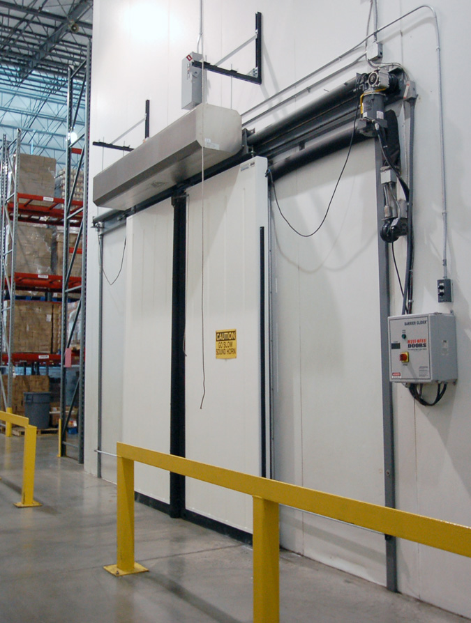 bên ngoài kho lạnh đang đóng lại có lắp một chiwwcs quạt cắt gió phía trên cửa lùa kho lạnh