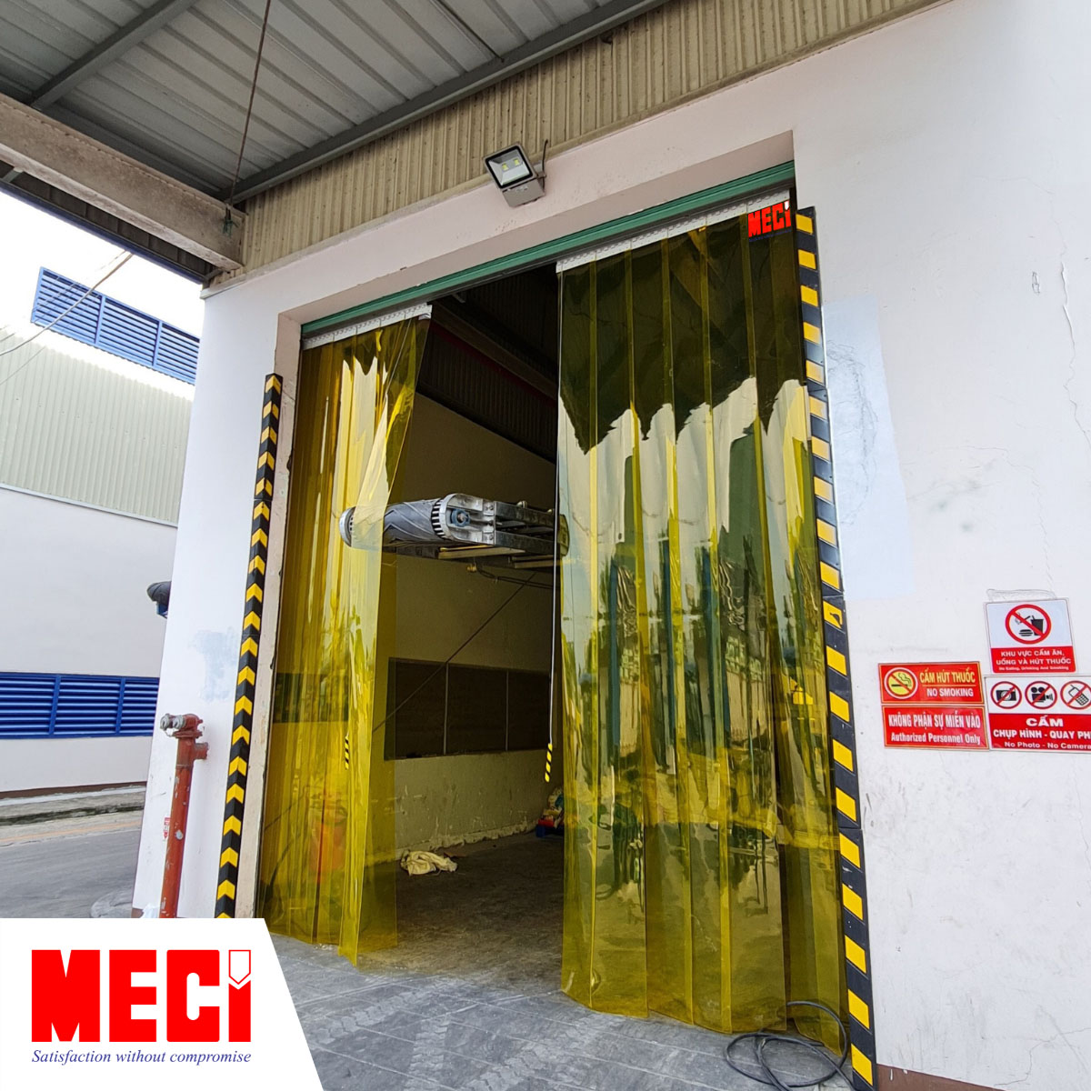 rèm nhựa pvc màu vàng thả sợi lắp tại một lối ra vào đang có một vật thể cồng kềnh đi qua