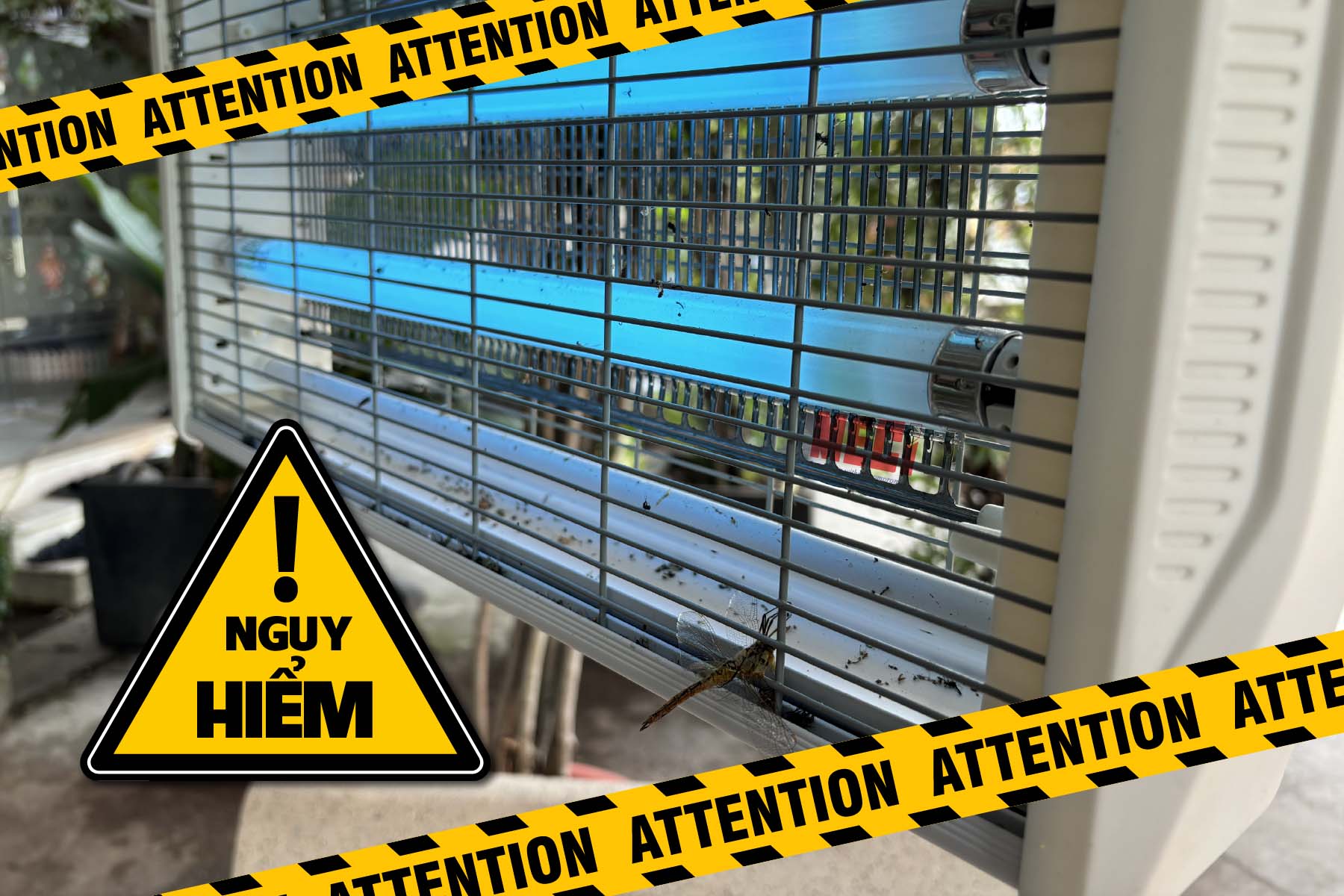 một cái đèn diệt côn trùng lưới điện đang treo trong vườn có khí hiệu cảnh báo nguy hiểm