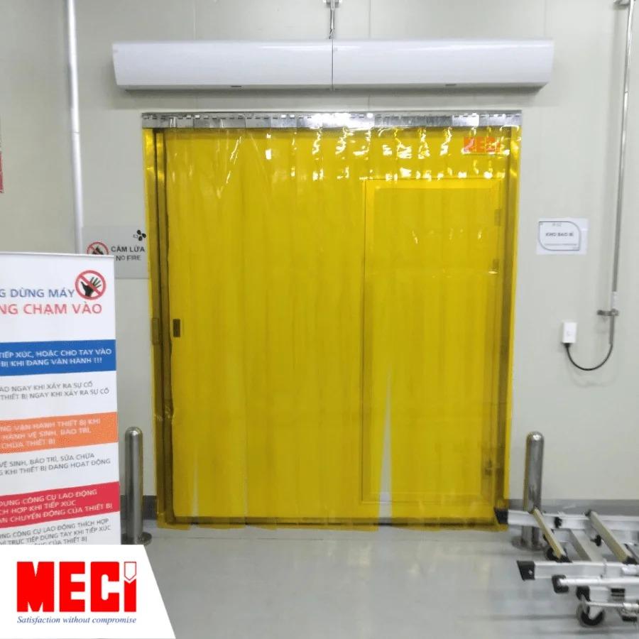 rèm nhựa PVC vàng lắp kết hợp với cửa phòng sạch, phía trên có 2 chiếc quạt cắt gió