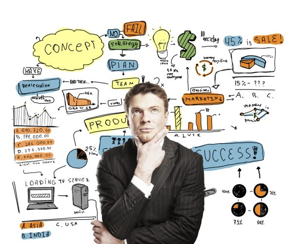 Một người đàn ông mặc vest đen đang đặt tay lên cằm suy nghĩ các vấn đề hiện diện bên sau.