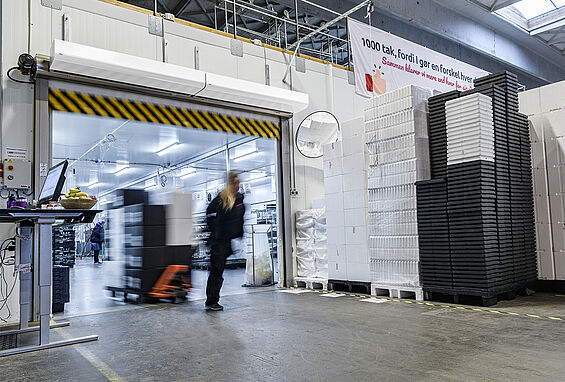 hình ảnh một người kéo xe hàng đi qua lối ra vào, phía trên lối đi có lắp quạt cắt gió