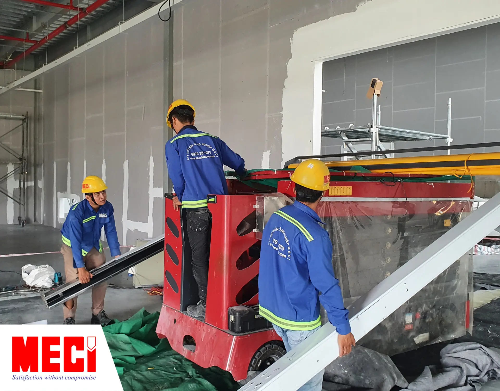 Kỹ thuật MECI đang dùng xe nâng lắp đặt cửa cuốn nhanh PVC.