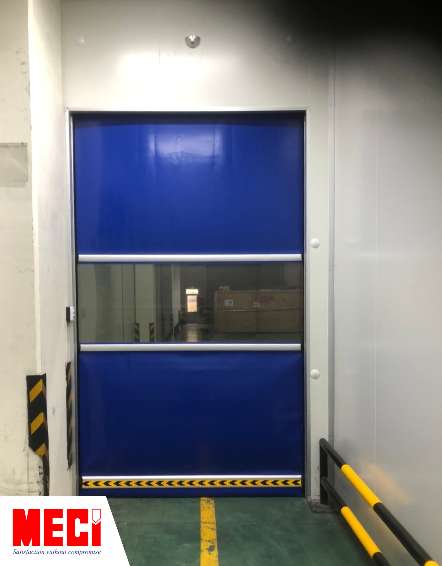 một chiếc cửa cuốn nhanh PVC màu xanh bên trong nhà máy