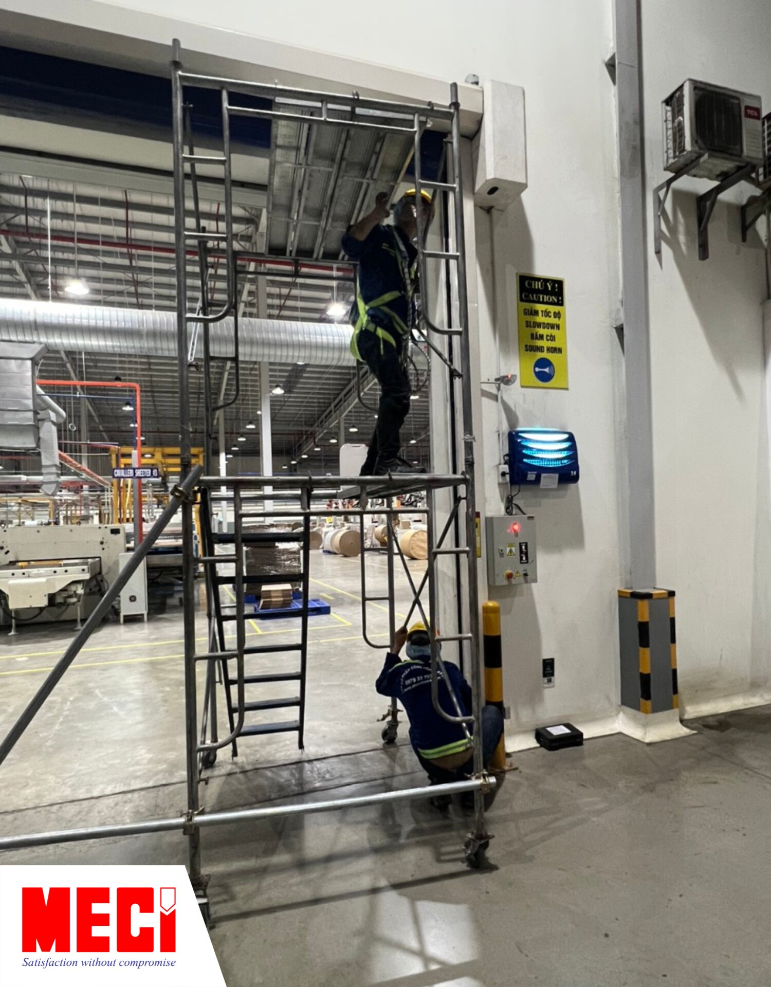 nhân viên MECI đang sửa chữa và thay thế linh kiện cho cửa cuốn nhanh PVC