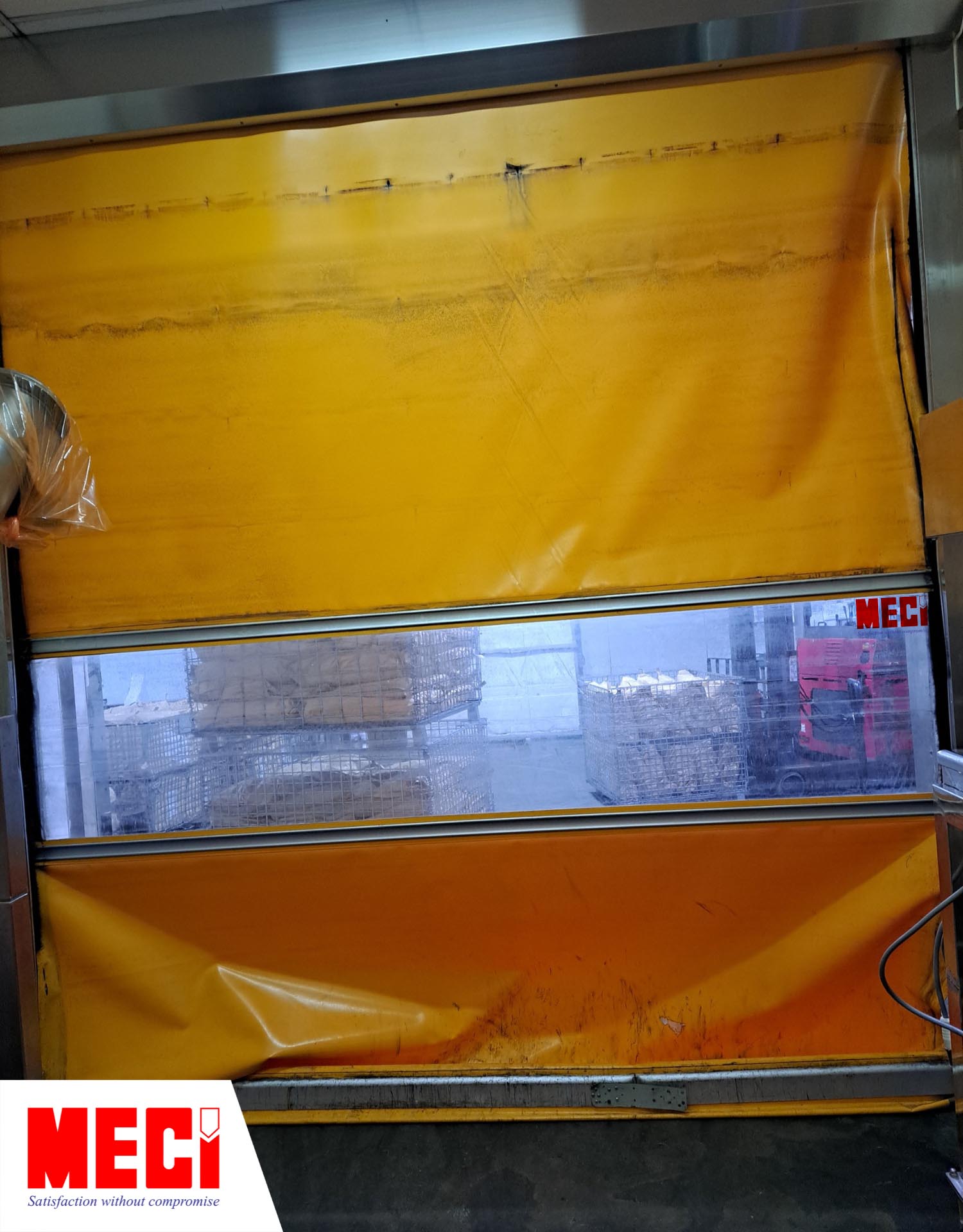 một chiếc cửa cuốn nhanh màu cam có tấm nhựa pvc nhăn nhúm