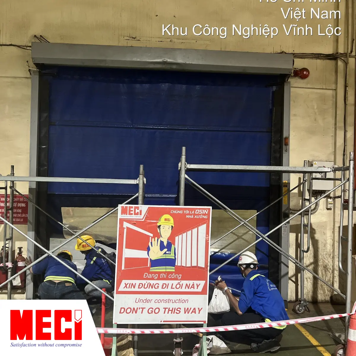 Nhân viên MECI đang giăng dây cảnh báo trước khi bảo trì cửa cuốn.