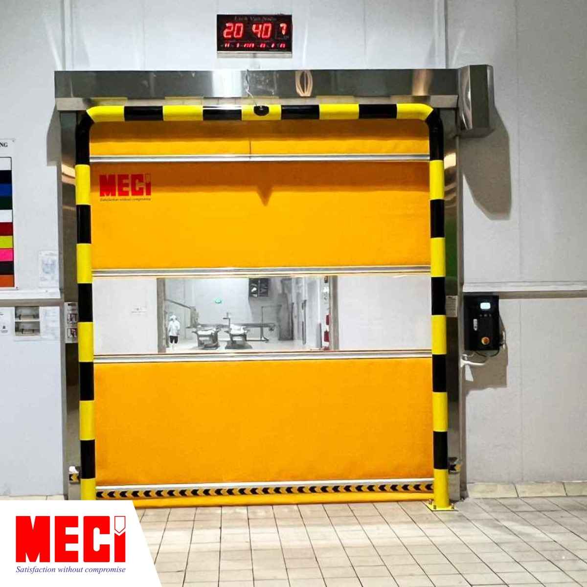 một cái cửa cuốn nhanh màu cam đang đóng, có khung chống va chạm bao quanh