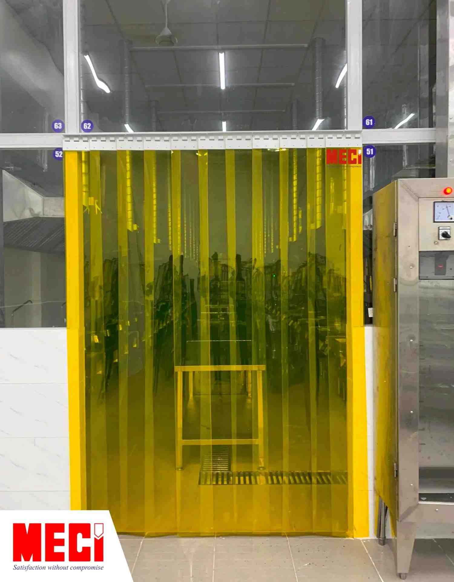 rèm nhựa PVC thả sợi màu vàng ở lối đi của 1 nhà máy