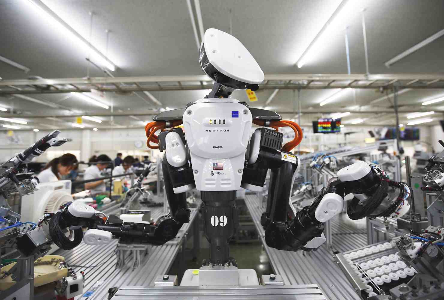 robot làm việc trong nhà máy, xung quanh có nhiều người 