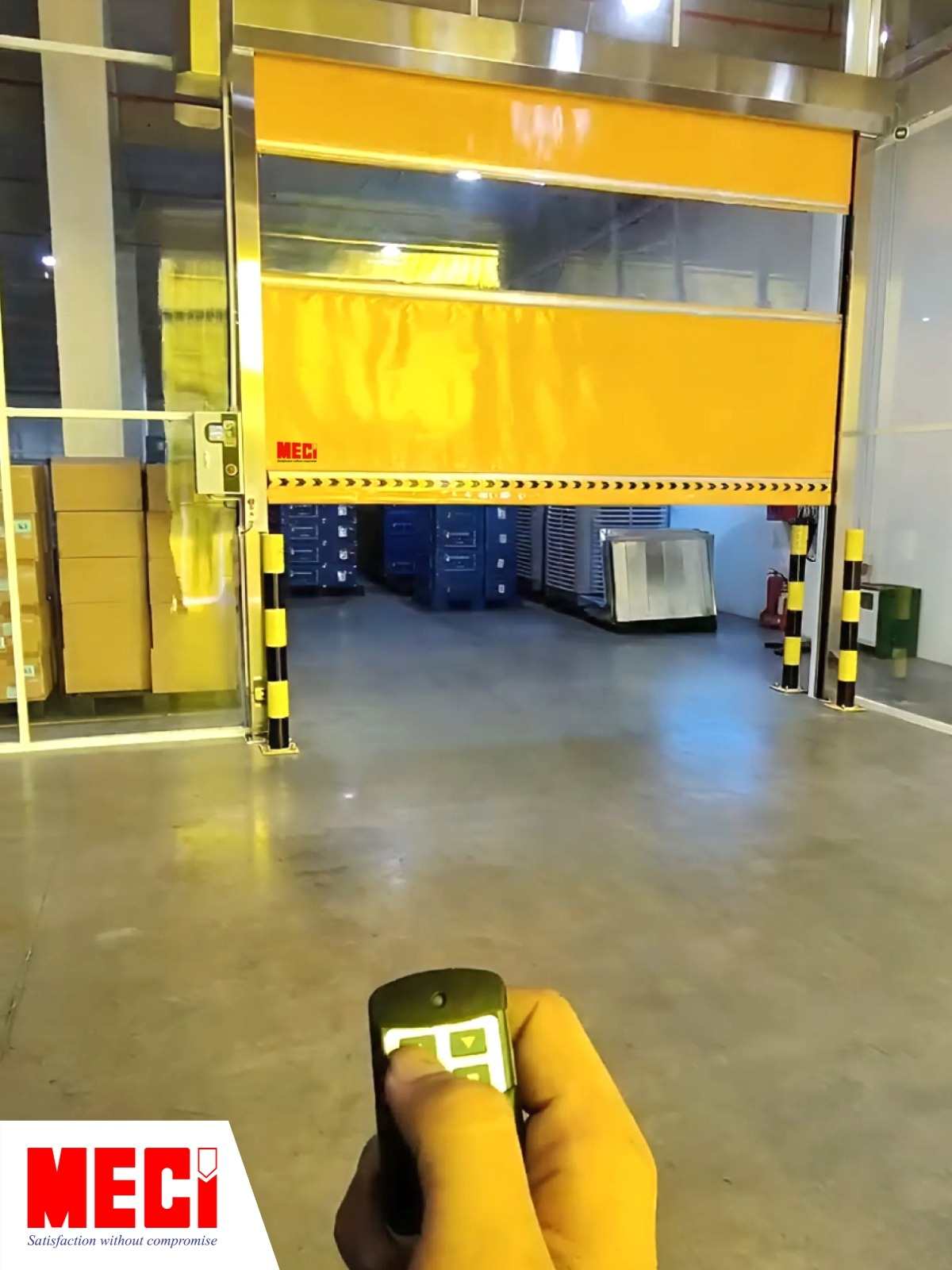 Cửa cuốn tốc độ cao đang mở và có một bàn tay đang đưa romote về hướng cửa