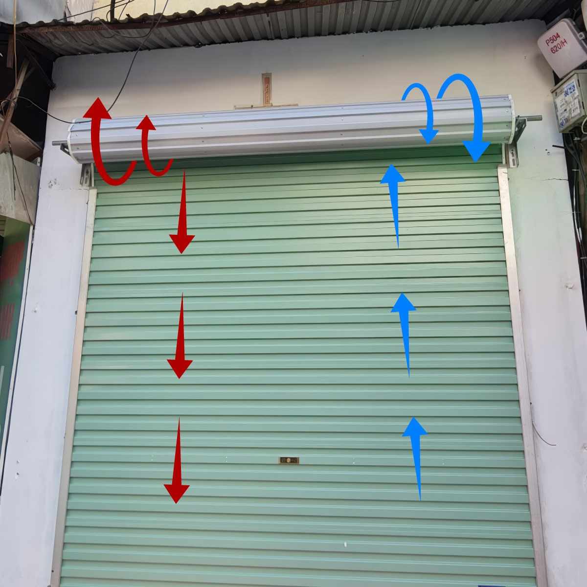 Cửa cuốn đang mở lên, có các mũi tên nẳm trên thân cửa và trục cuốn