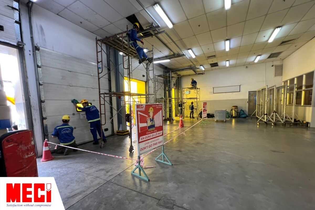 Đội ngũ MECI Sài Gòn thi công qui trình bảo trì cửa trượt trần tại một nhà xưởng