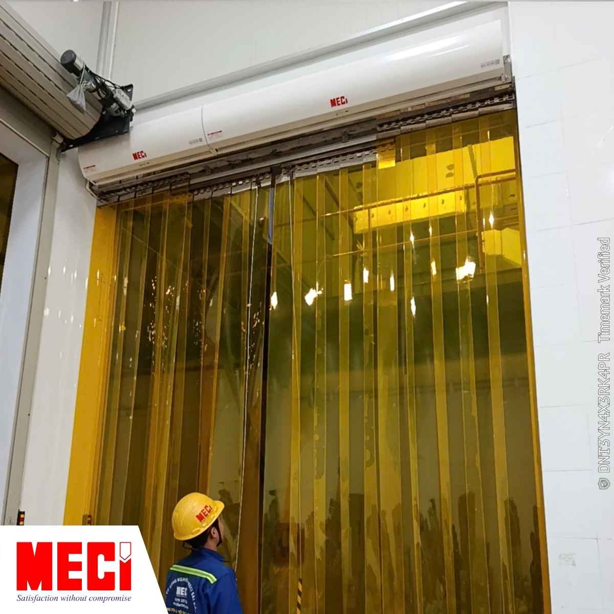 Kỹ thuật viên đang cầm dây kéo của rèm nhựa PVC, phía trên là 2 quạt cắt gió MECI