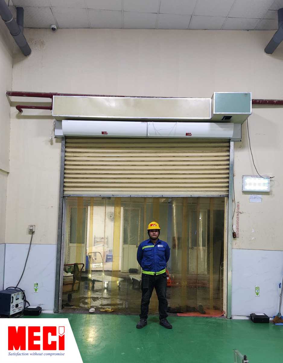 cửa cuốn nhôm kết hợp cùng quạt cắt gió và rèm nhựa PVC tại Fancy Foods có 1 kỹ thuật đứng trước cửa