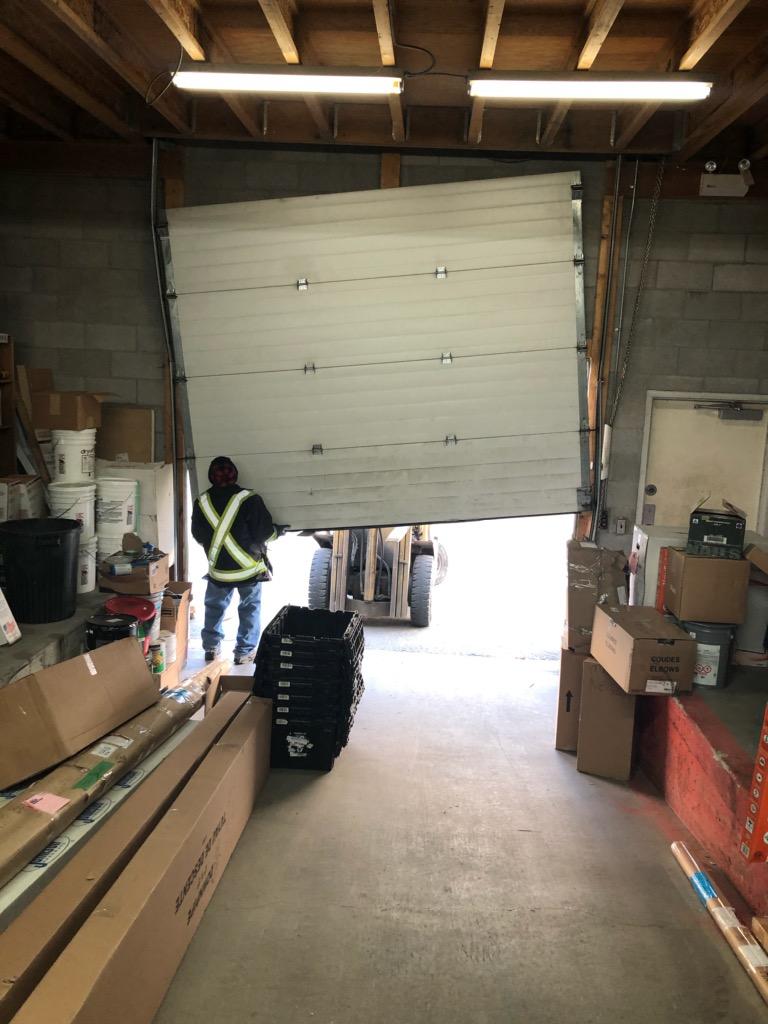 cử trượt trần tại một nhà xưởng bị rơi thân cửa, một người đàn ông đang sửa lại