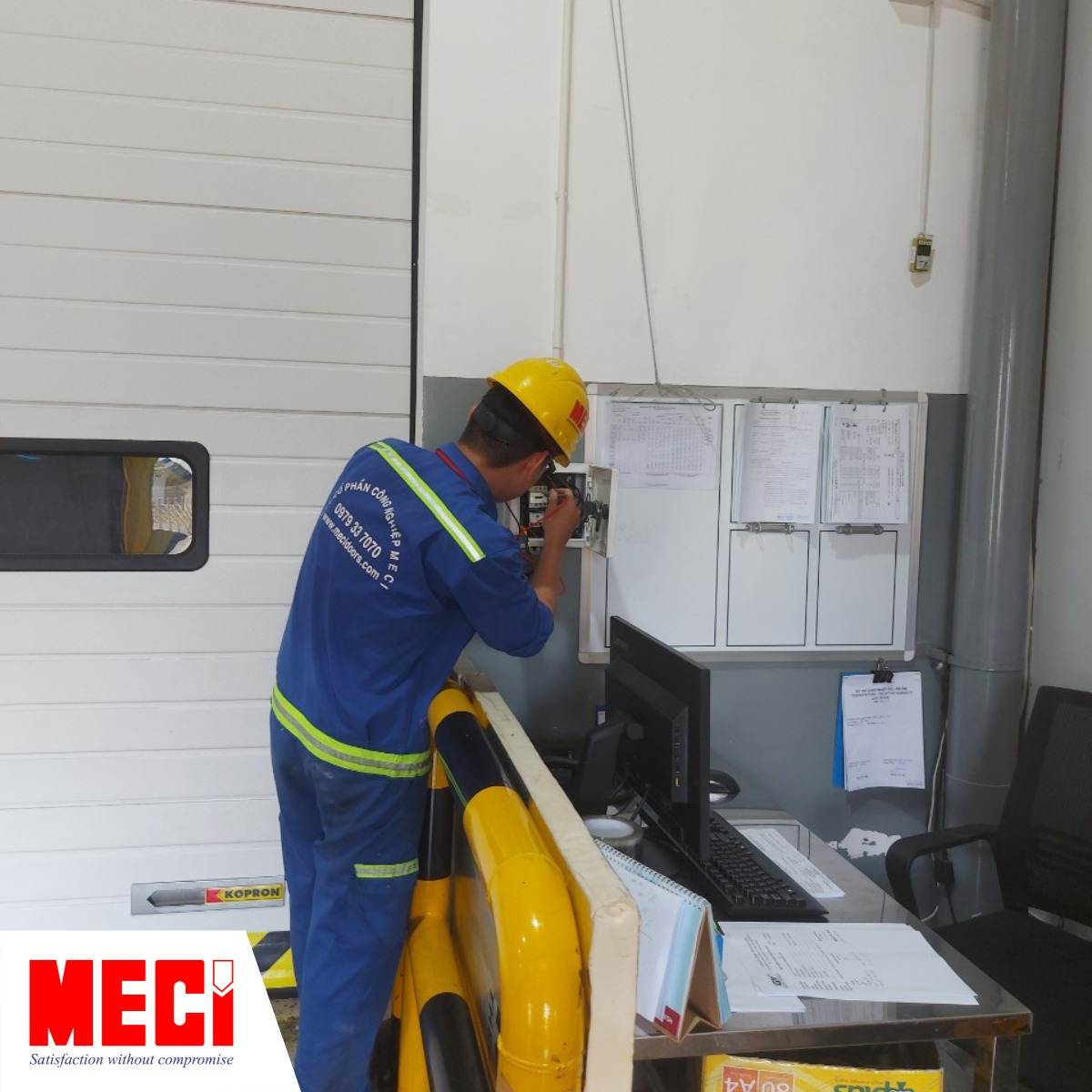 một kỹ thuật đang kiểm tra bên trong tủ điều khiển cửa trượt trần