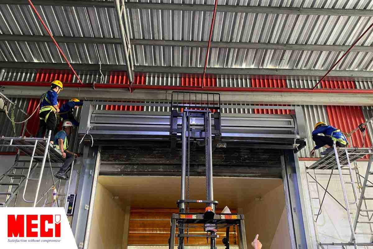 Đội ngũ thi công MECI đang lắp đặt cửa cuốn nhanh nan nhôm.