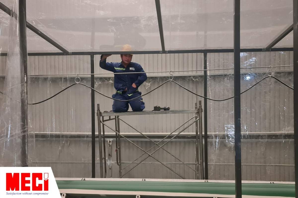 kỹ thuật MECI đang đứng trên cao để lắp đặt vách ngăn nhựa