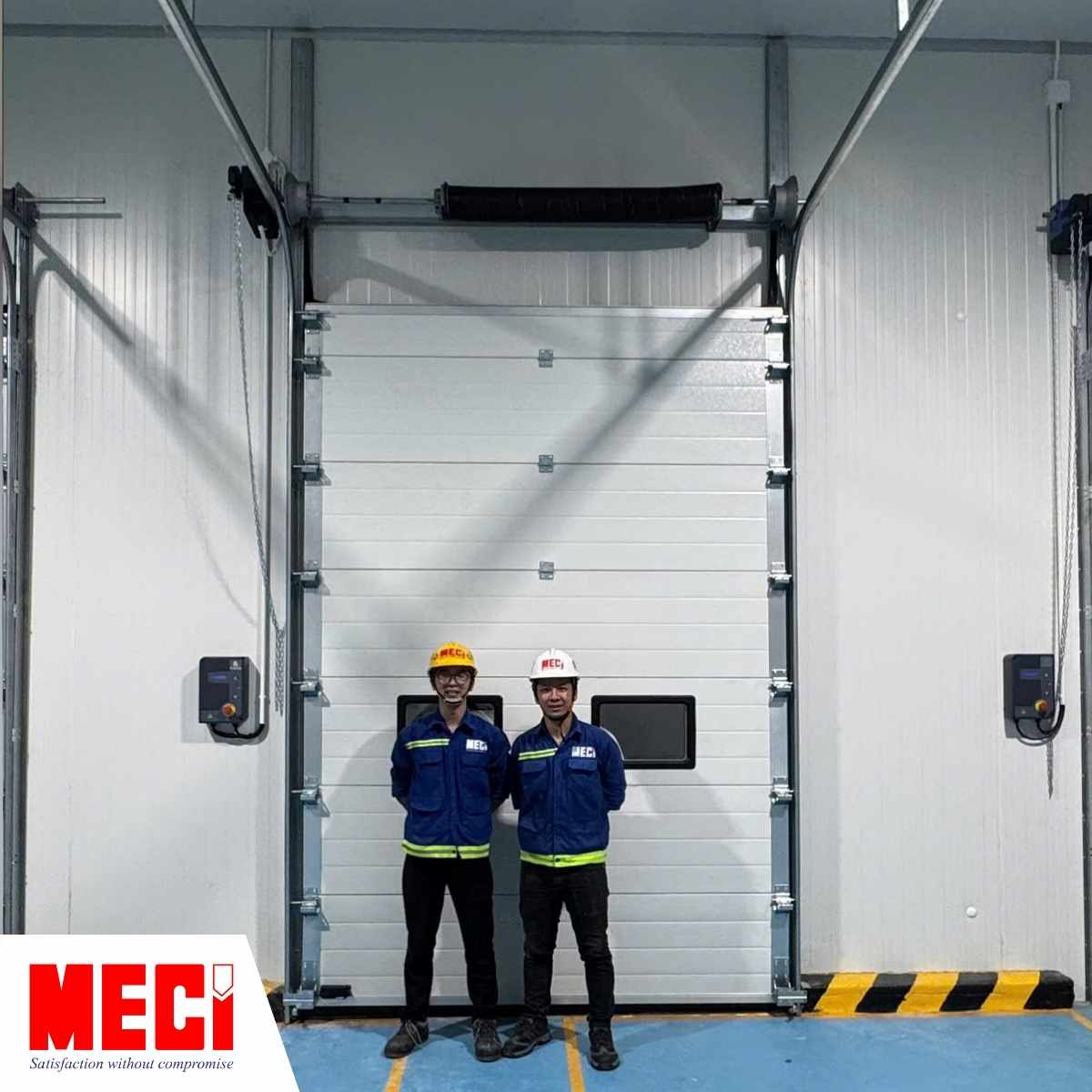 2 kỹ thuật viên của MECI đang đứng trước cửa trượt trần panel MECI