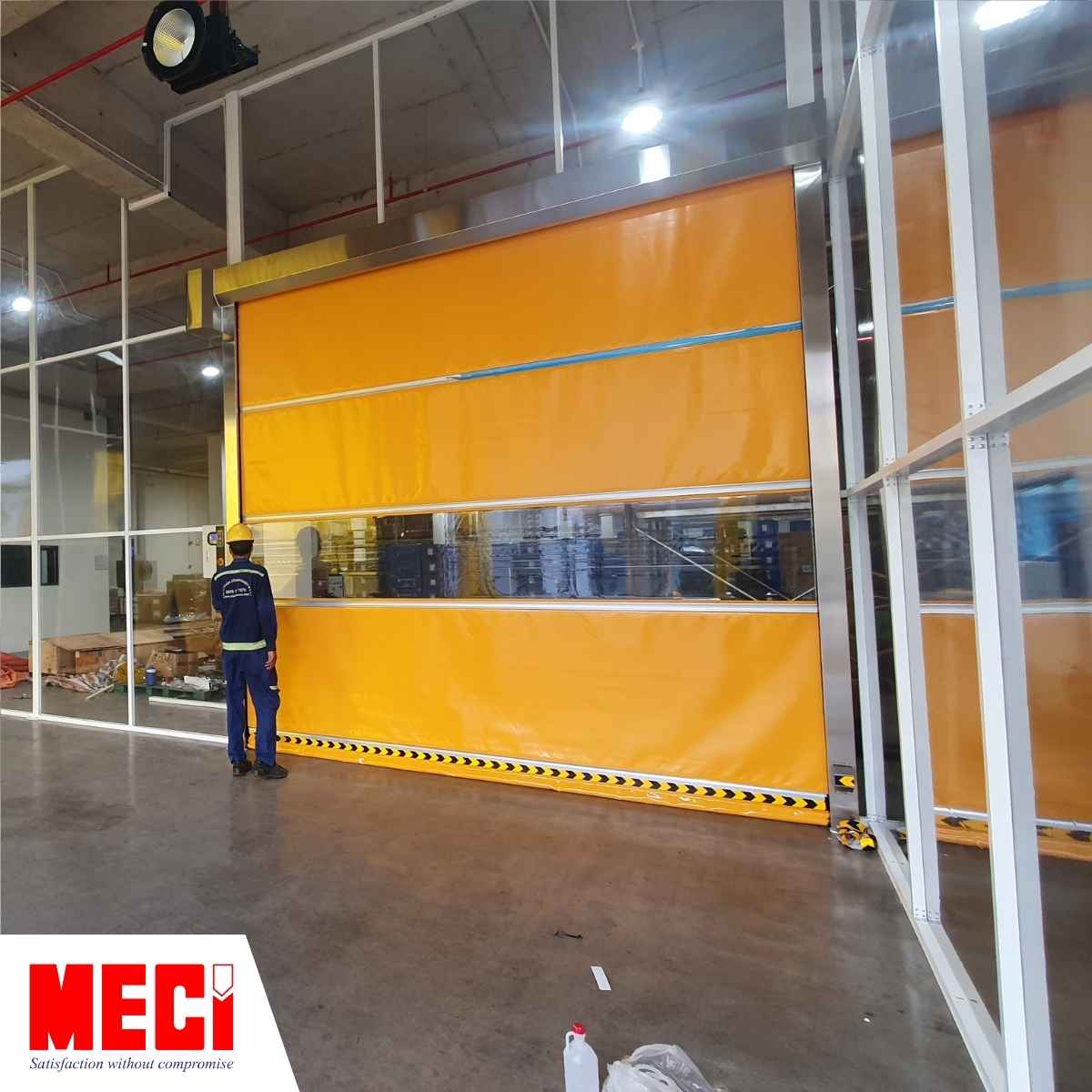 Nhân viên đang đứng cạnh cửa cuốn nhanh kết hợp vách ngăn nhựa